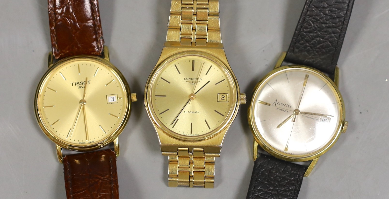 Three assorted gentleman's wrist watches, including a steel and gold plated Longines automatic, Tissot and Accurist.